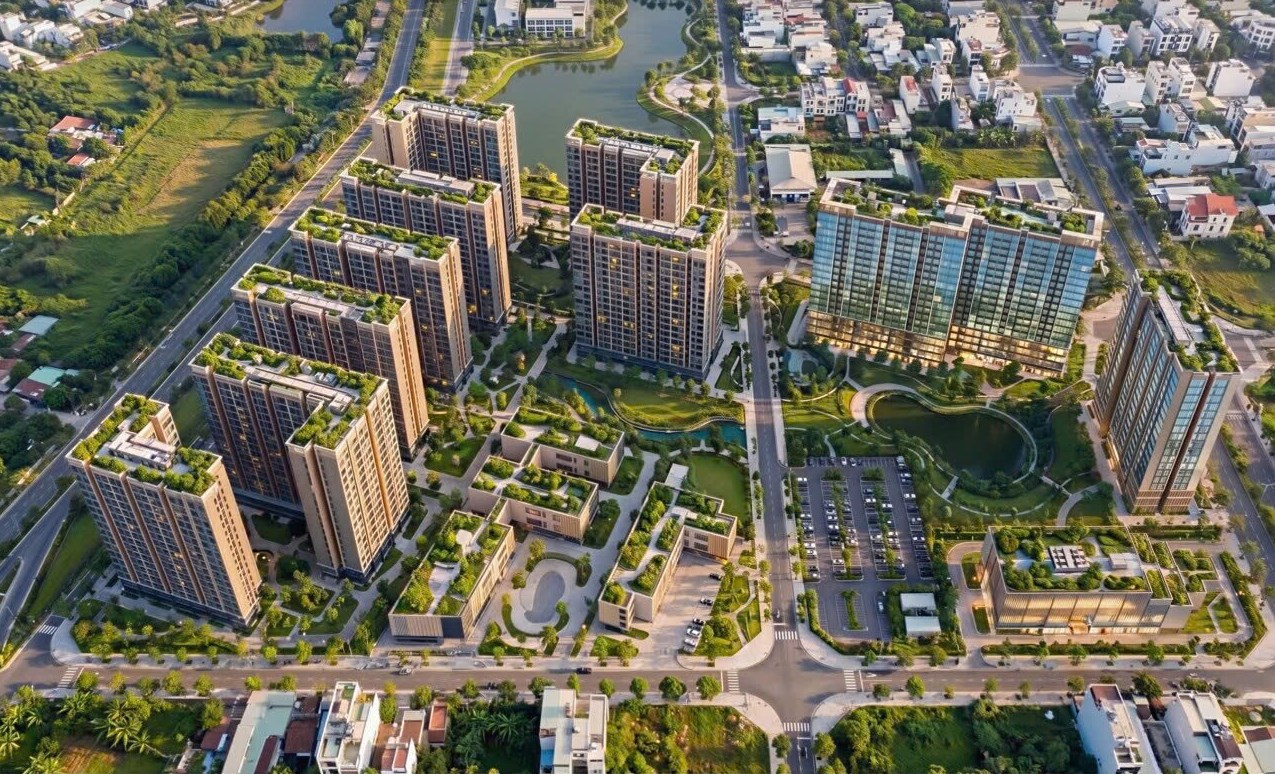Phối cảnh tổng thể dự án nhìn từ trên cao — các toà nhà ở xã hội, khối chung cư, trường học, bãi đỗ xe, hồ và công viên cây xanh